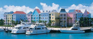 Un port de plaisance avec des bâtiments aux couleurs vives et des yachts amarrés.