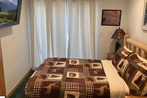 Une chambre à coucher avec un lit, une table de chevet, une lampe et un tableau au mur.