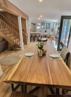 A dining area with a wooden table, chairs, and a staircase. - New! Walking distance to the lake and beach! (Kings Beach)