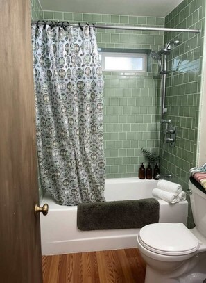 Ein Badezimmer mit Dusche, Toilette und Badewanne.