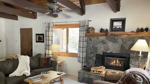A cozy living room with a fireplace, a sofa, a coffee table, and a couch. - Cabin close to hiking trails and ski resorts (South Lake Tahoe)