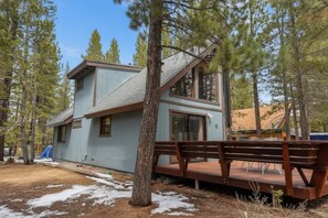 A two-story cabin with a deck, surrounded by tall pine trees. - Only 7 miles to Heavenly, Huge Deck, Pets Welcome (South Lake Tahoe)