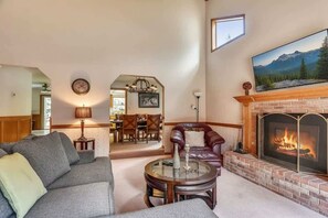 A living room with a fireplace, a dining area, and a view of mountains. - Minutes to Heavenly, Private Covered Hot Tub (South Lake Tahoe)