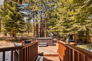 A wooden deck with a hot tub and seating area surrounded by tall pine trees. - Minutes to Heavenly, Private Covered Hot Tub (South Lake Tahoe)