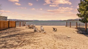 A beach with a wooden fence, outdoor seating, and a view of the ocean. - Private Beach, Lakefront Home, Close to Everything (South Lake Tahoe)