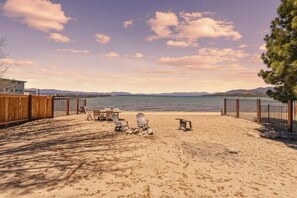 A beach with a wooden fence, outdoor seating, and a view of the ocean. - Private Beach, Lakefront Home, Close to Everything (South Lake Tahoe)