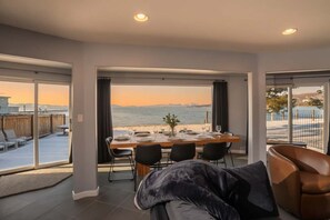 A dining area with a view of the sea, a large window, and a modern interior design. - Private Beach, Lakefront Home, Close to Everything (South Lake Tahoe)