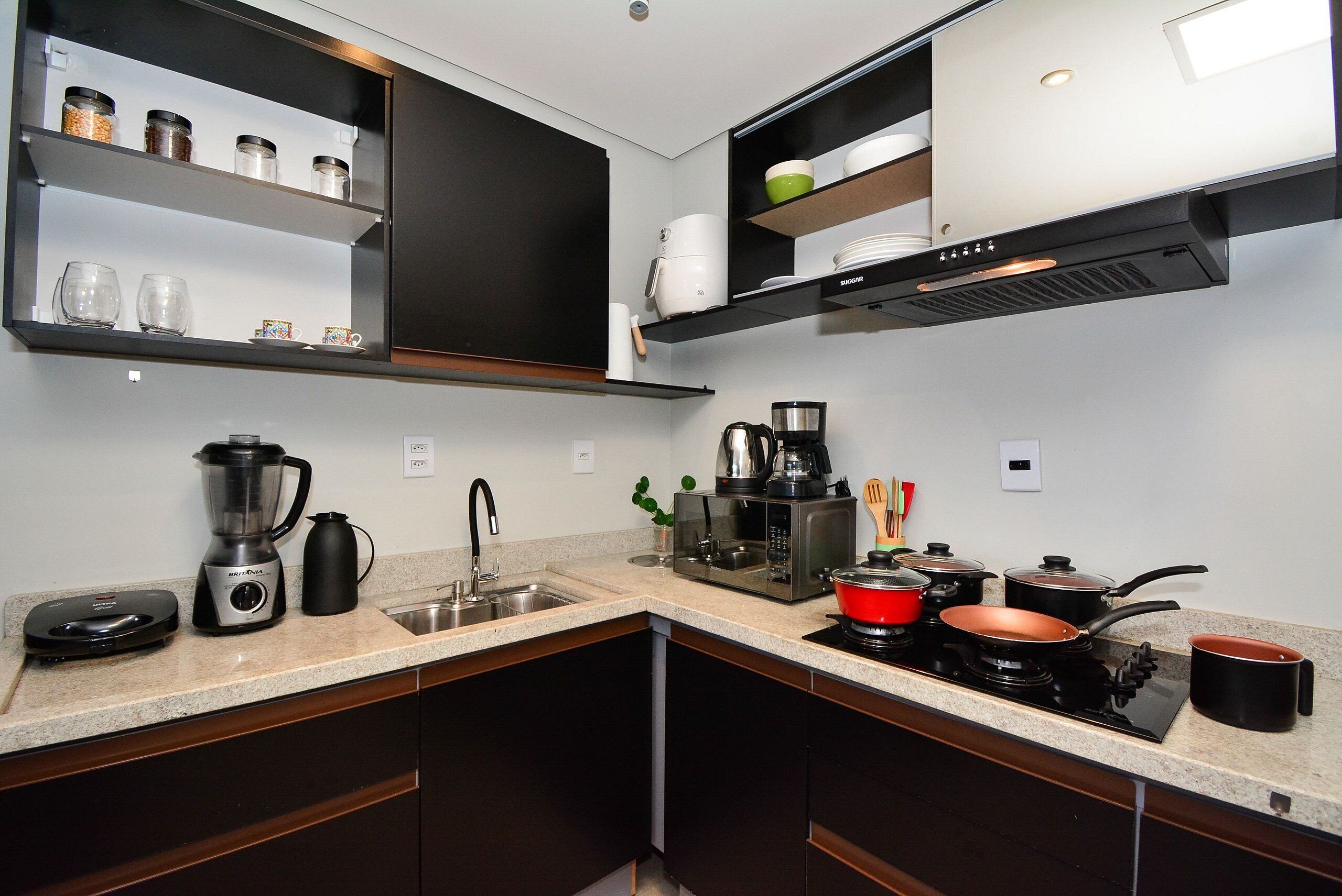 Una cocina moderna con lavavajillas integrado, cafetera, microondas y estufa.