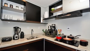Una cocina moderna con lavavajillas integrado, cafetera, microondas y estufa.