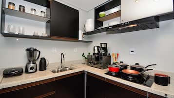 Una cocina moderna con lavavajillas integrado, cafetera, microondas y estufa.