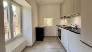 Una cocina estrecha con una ventana y un lavabo.