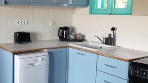 A kitchen with a dishwasher, stove, sink, and cabinets.