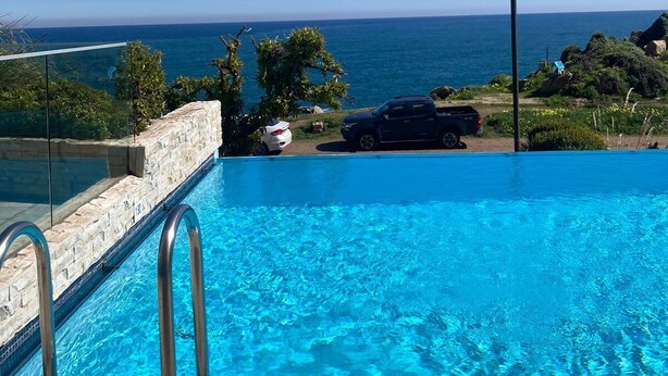 A clear blue swimming pool with a view of the ocean and a flagpole. - Apartment in Concon, in front of the sea. Wonderful view. 5 people, very complete. (Concón)