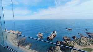A coastal view from a high vantage point, featuring rocky outcrops in the sea, a clear sky, and a road with vehicles. - Apartment in Concon, in front of the sea. Wonderful view. 5 people, very complete. (Concón)
