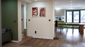 Een modern interieur met een eethoek, een bank en kunstwerken aan de muren.