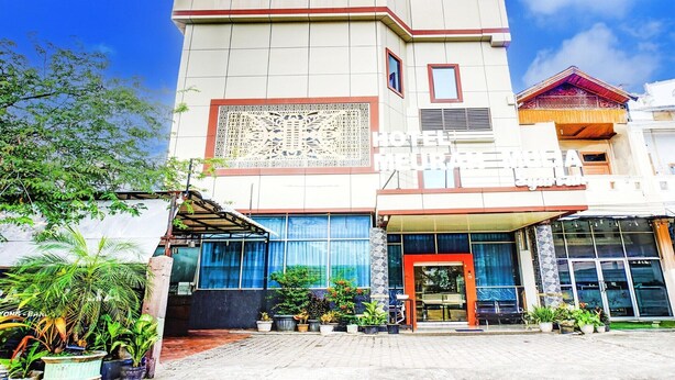 A hotel named 'MEURAH MULIA' with a modern facade, large windows, and a covered entrance area. - Cozy Twin Escape in Indonesia with Free WiFi (Banda Aceh)