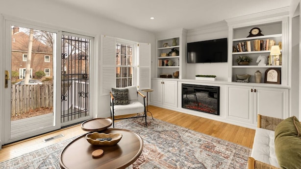 A living room with a fireplace, a television, and a bookshelf. - Your Old Town Home Away From Home (Alexandria)