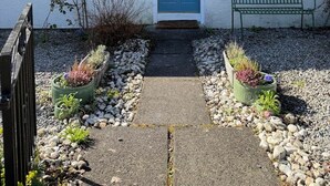 A house with a blue door, number 7, and a bench in the front yard. - Faerie Cottage, Luss, Loch Lomond (Luss)