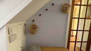 A room with a wooden bench, a white wardrobe, a door, and a window with a view. - Faerie Cottage, Luss, Loch Lomond (Luss)