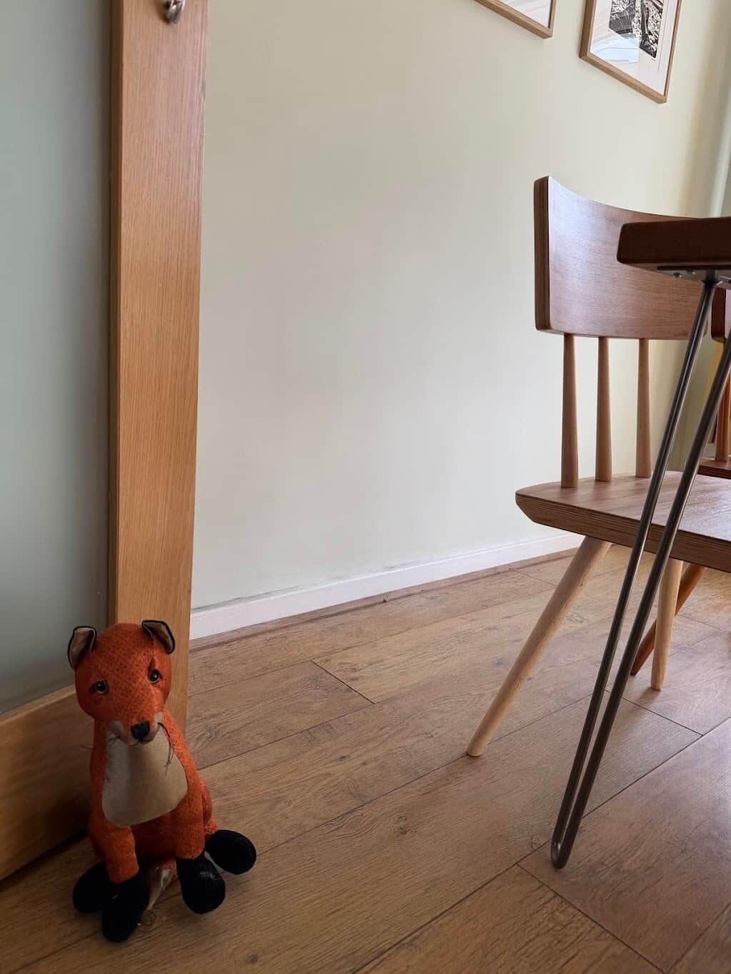 A wooden floor, a wooden chair, and a plush toy.