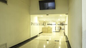Corredor com porta de vidro identificada como 'Heritage Pasarbaru'.