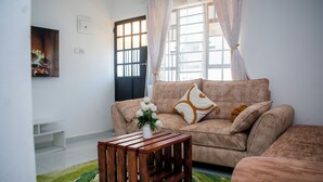 Ein Wohnzimmer mit einer Couch, einem Couchtisch aus Holz und einem gemusterten Teppich.