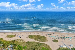 A beach with a clear view of the ocean, a sandy shore, and some greenery. - 3BR Beach Retreat | Heated Pool + Parking (Pompano Beach)