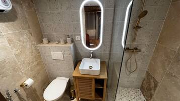 Een douche, handdoeken, zeep, toiletpapier