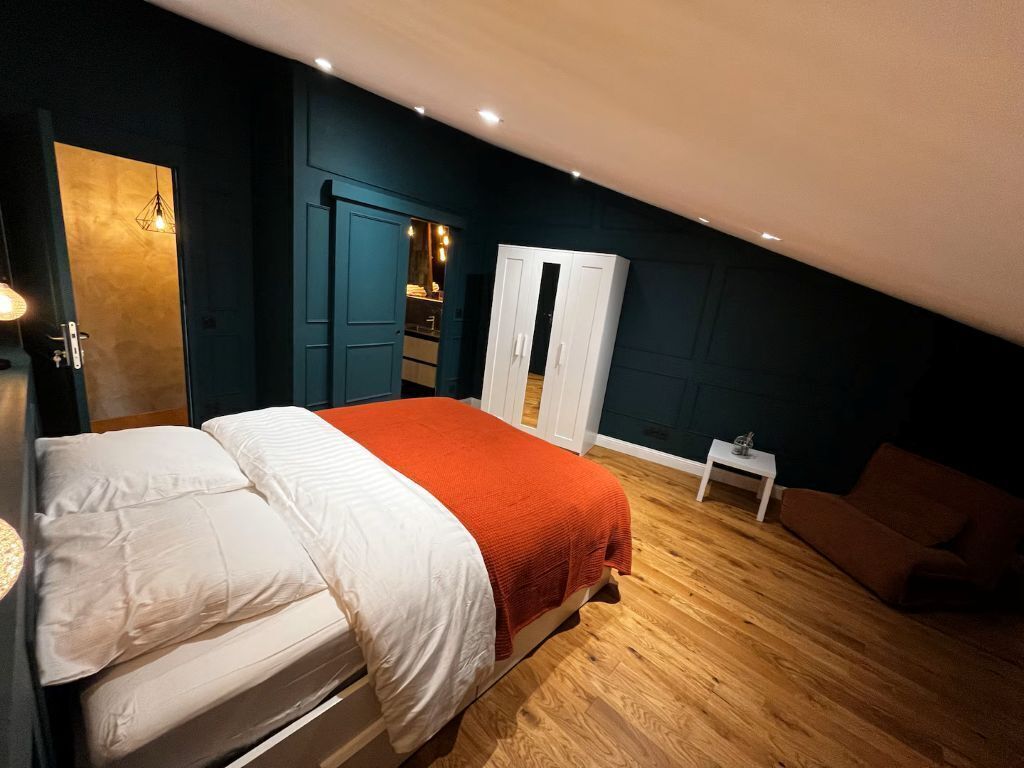 Une chambre à coucher comprenant un lit, une armoire, une table de chevet et une chaise.