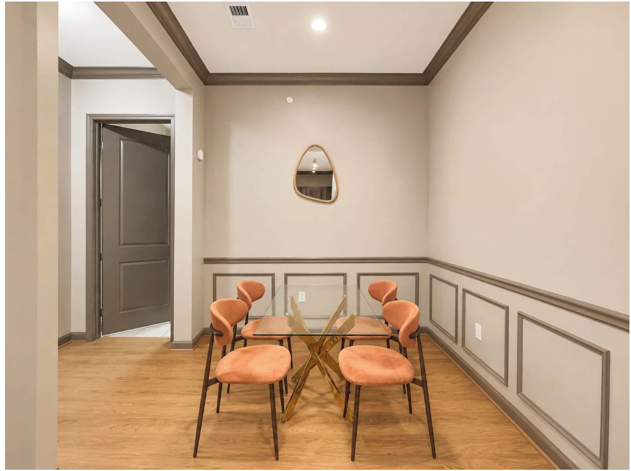 A room with a dining table, six chairs, a mirror, and a door.