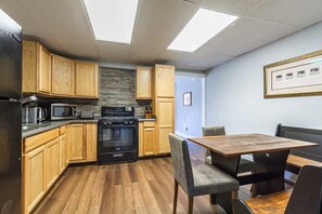 A compact kitchen with wooden cabinets, a built-in oven, and a microwave.