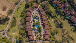 Vista aérea de uma área residencial com casas, piscina e campo de golfe.