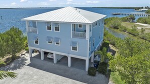 A two-story building with a balcony, located near a body of water. - TOP FLORIDA's Villa Porpoise Point (Cape Coral)