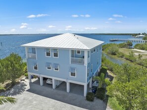 A two-story building with a balcony, located near a body of water. - TOP FLORIDA's Villa Porpoise Point (Cape Coral)