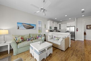 A living room with a sofa, a coffee table, a dining table, and a kitchen in the background. - TOP FLORIDA's Villa Porpoise Point (Cape Coral)