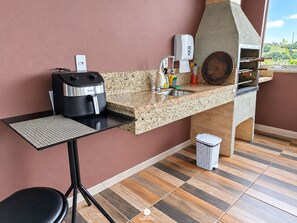 Cocina compacta con cafetera, pileta y parrilla integrada.