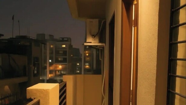 A corridor with a marble floor, a window with a metal grill, and a door. - 2-bedroom apartment in perfect Patna with cool AC (Patna)