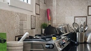 A kitchen with a gas stove, a mortar and pestle, and a utensil holder. - 2-bedroom apartment in perfect Patna with cool AC (Patna)