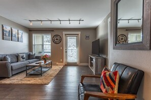 A living room with a sofa, coffee table, TV, and a mirror. - The Peachtree Paradise: Hot Tub, Free Shuttle (Crested Butte)
