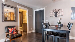 A dining area with a dark wooden table and chairs, a mirror, and a door leading to a bathroom. - The Peachtree Paradise: Hot Tub, Free Shuttle (Crested Butte)