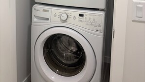 Eine gestapelte Waschmaschine und ein Trockner in einem Waschraum.