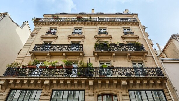 Un edificio a più piani con balconi decorati, ampie finestre e uno stile architettonico classico.