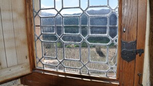 Une porte en bois dotée d’une fenêtre en verre ornée d’un motif géométrique.