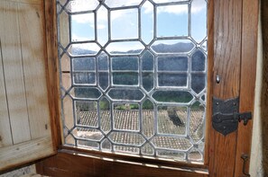 A wooden door with a glass window featuring a geometric pattern.