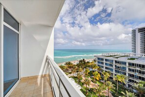 Ein Balkon mit Blick auf den Ozean und ein modernes Gebäude mit Dachgarten.