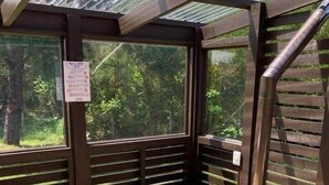 A wooden hot tub with a metal frame, surrounded by wooden railings and large windows. - Fully equipped cabin in Chiloé, steps from the beach (Ancud)