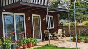 A two-story wooden house with a balcony, potted plants, and outdoor furniture. - A two-storey wooden villa fully equipped with all amenities with Love (Durrës)