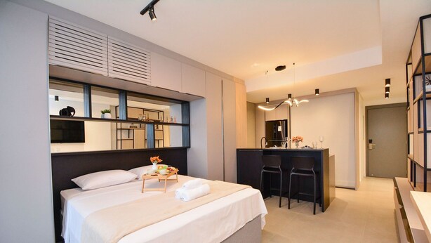 Una habitación de hotel moderna con una cama grande, un escritorio y una silla.