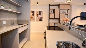 Una cocina moderna con estantes empotrados, una isla central y un elemento decorativo en la pared.