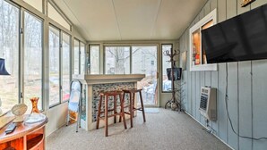 A room with a bar area, large windows, a television, and a fireplace. - Walk to Locust Lake - Poconos Home w Fire Pit! (Pocono Lake)